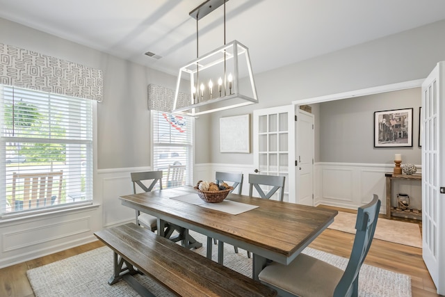 627 Macintyre Cir, Summerville, SC 29486 - dining area with a wainscoted wall, healthy amount of natural light, a decorative wall, light wood finished floors, and a chandelier