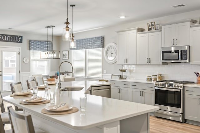 627 Macintyre Cir, Summerville, SC 29486 - kitchen featuring appliances with stainless steel finishes, a sink, light countertops, an island with sink, and wainscoting