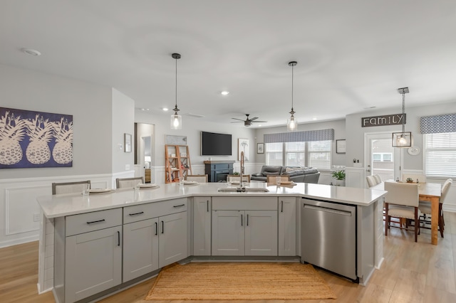 627 Macintyre Cir, Summerville, SC 29486 - kitchen featuring stainless steel dishwasher, a sink, open floor plan, a wainscoted wall, and light countertops