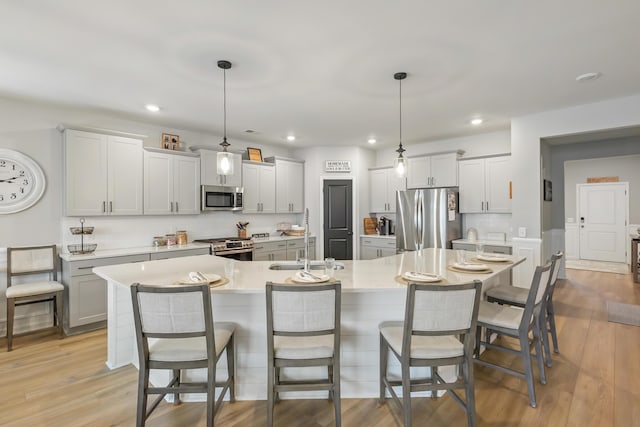 627 Macintyre Cir, Summerville, SC 29486 - kitchen with stainless steel appliances, light countertops, a kitchen breakfast bar, recessed lighting, and light wood-style flooring