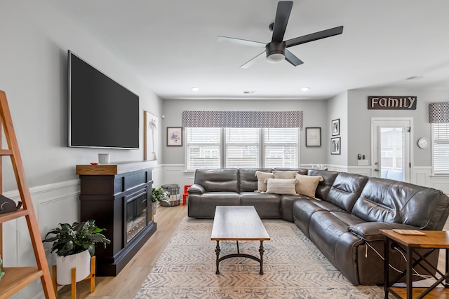 627 Macintyre Cir, Summerville, SC 29486 - living area with a wainscoted wall, ceiling fan, light wood finished floors, a decorative wall, and a glass covered fireplace