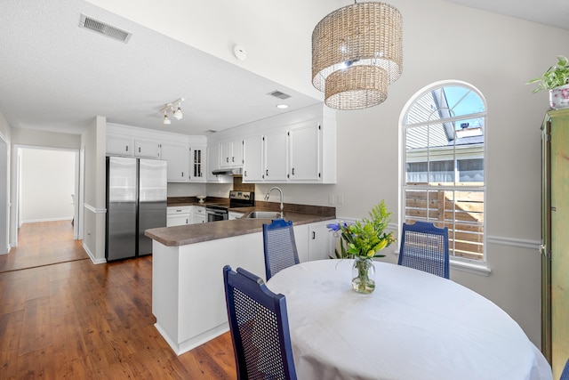 kitchen with visible vents, dark countertops, appliances with stainless steel finishes, white cabinetry, and a notable chandelier