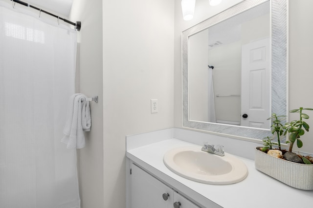 bathroom with curtained shower, visible vents, and vanity