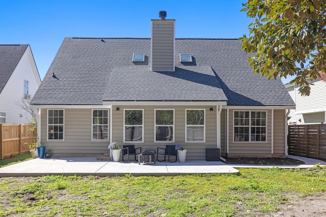 back of property featuring a lawn, fence, a chimney, and a patio