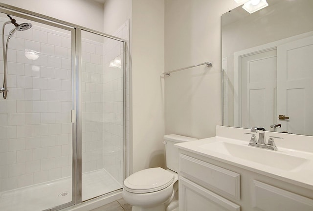 bathroom featuring tile patterned floors, vanity, toilet, and a shower with door