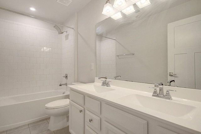 full bathroom with tile patterned floors, vanity, tiled shower / bath combo, and toilet