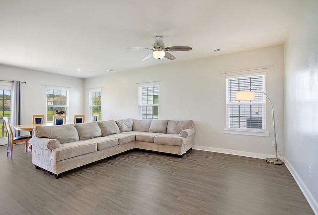 living room with dark hardwood / wood-style flooring and ceiling fan