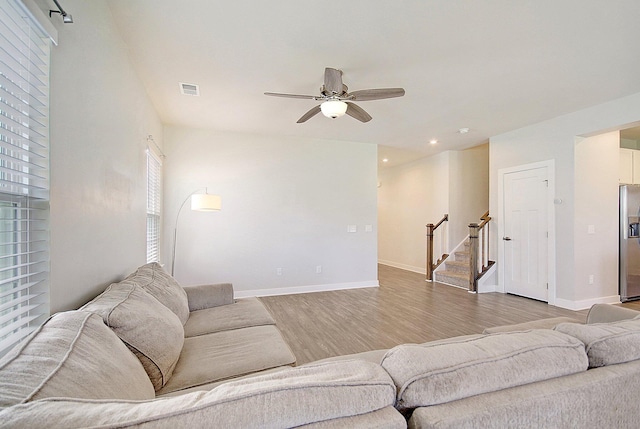 living room with light wood-type flooring and ceiling fan