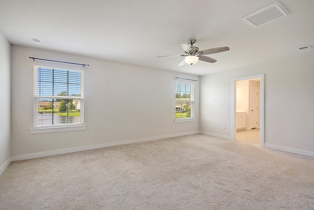 empty room featuring ceiling fan and light carpet