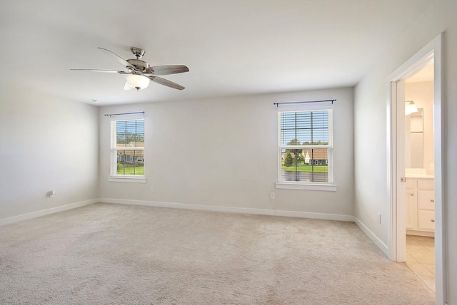 carpeted spare room featuring ceiling fan