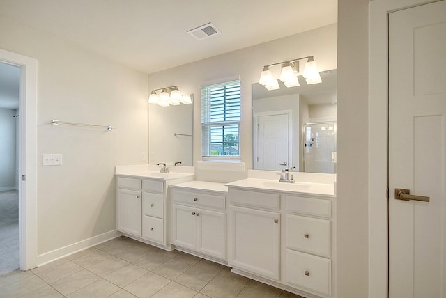 bathroom with tile patterned flooring, vanity, and a shower with door