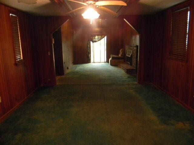 hall with dark carpet and wooden walls