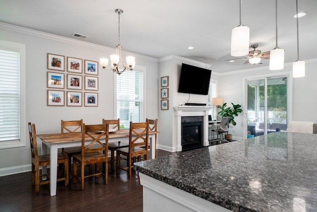 1630 Mermentau St, Mount Pleasant, SC 29466 - dining space with ornamental molding, a ceiling fan, a chandelier, a glass covered fireplace, and dark wood-type flooring