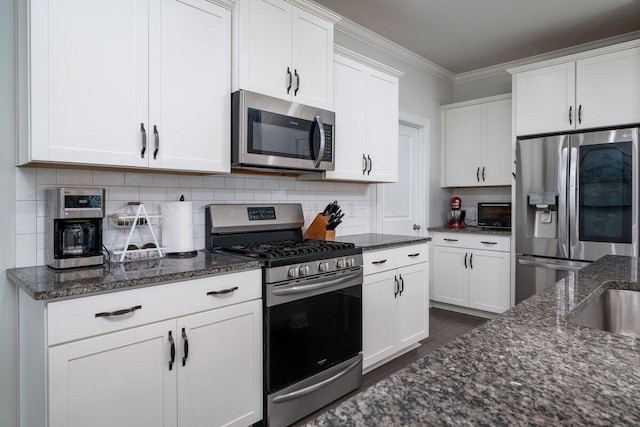 1630 Mermentau St, Mount Pleasant, SC 29466 - kitchen with stainless steel appliances, white cabinets, dark stone counters, dark wood-style floors, and crown molding