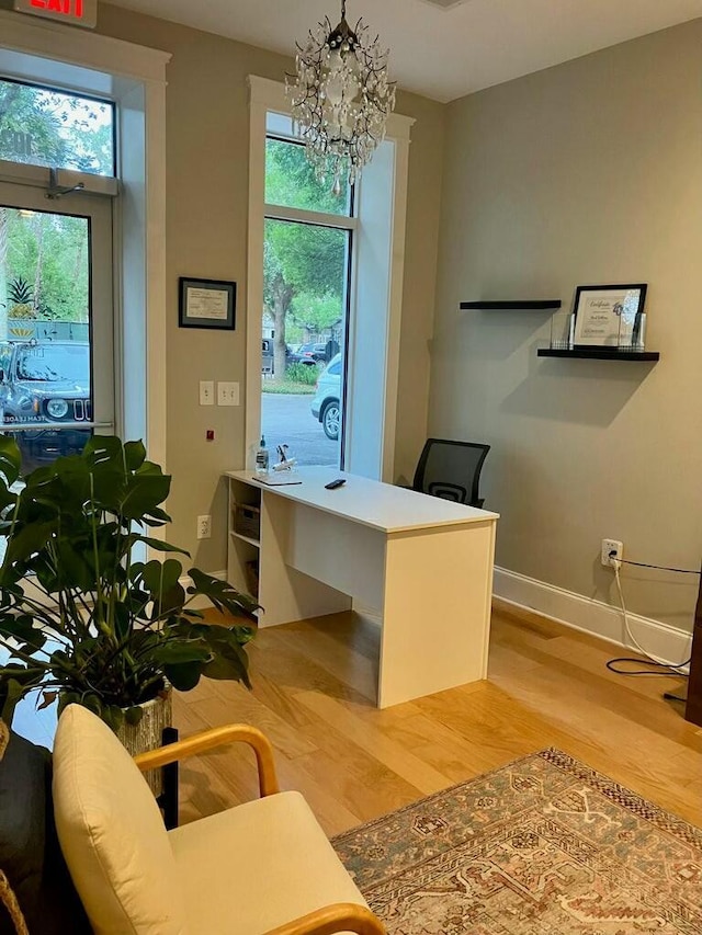 office featuring a chandelier, a healthy amount of sunlight, and light wood-type flooring