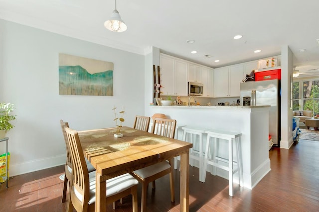 dining space featuring crown molding, dark wood-type flooring, and ceiling fan