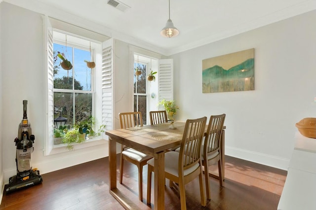 dining area featuring crown molding and dark hardwood / wood-style flooring