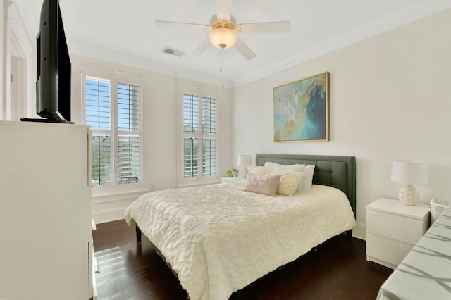 bedroom with crown molding, dark wood-type flooring, and ceiling fan