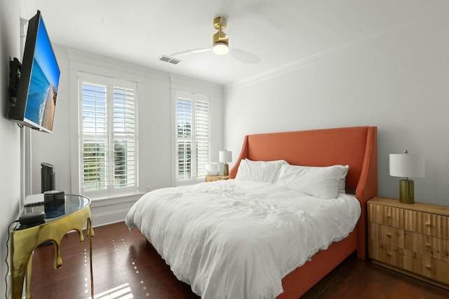 bedroom with dark hardwood / wood-style flooring, crown molding, and ceiling fan