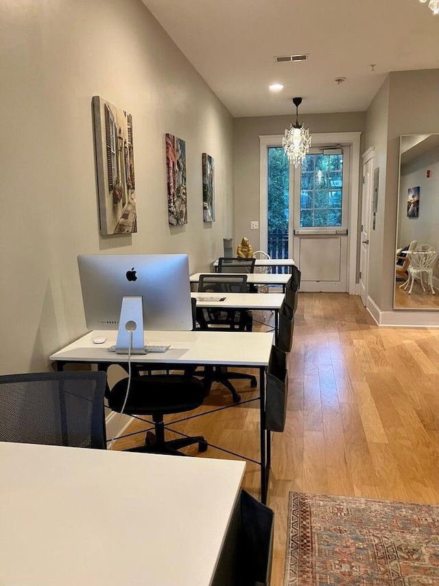 dining space with an inviting chandelier and light hardwood / wood-style flooring