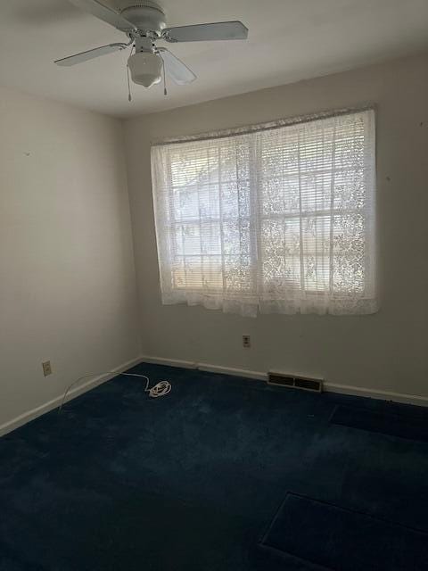 spare room featuring ceiling fan and carpet flooring