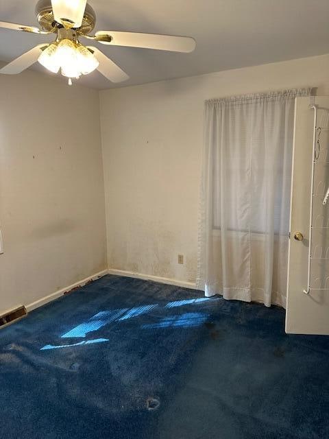 carpeted empty room featuring ceiling fan