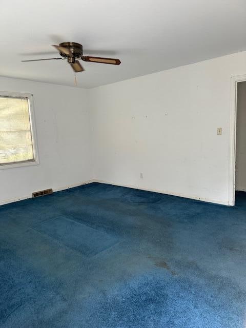 carpeted spare room featuring ceiling fan