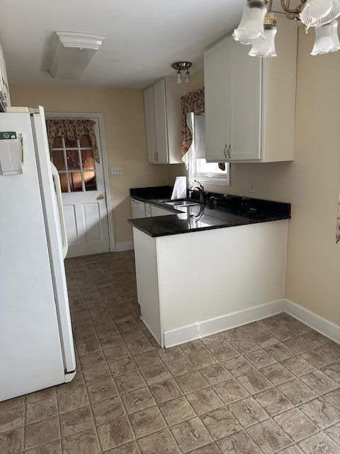 kitchen with white cabinets, white fridge, and sink