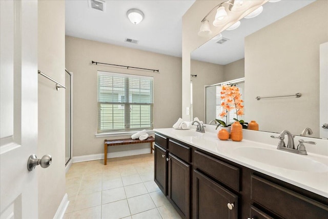 bathroom featuring tile patterned flooring, vanity, and a shower with door