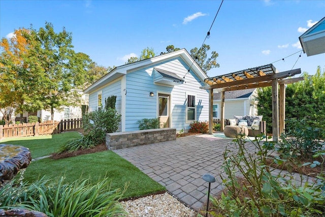 back of house featuring a patio, a pergola, and a lawn