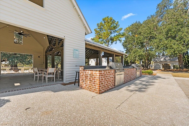 view of side of home featuring exterior bar, a patio area, ceiling fan, and an outdoor kitchen