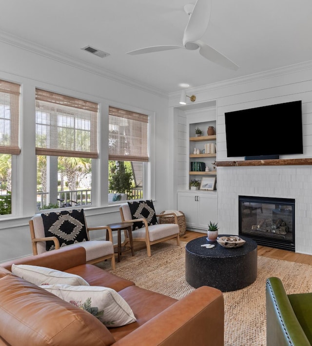 1530 Willtown St, Daniel Island, SC 29492 - living area featuring ornamental molding, healthy amount of natural light, wood finished floors, a ceiling fan, and built in shelves