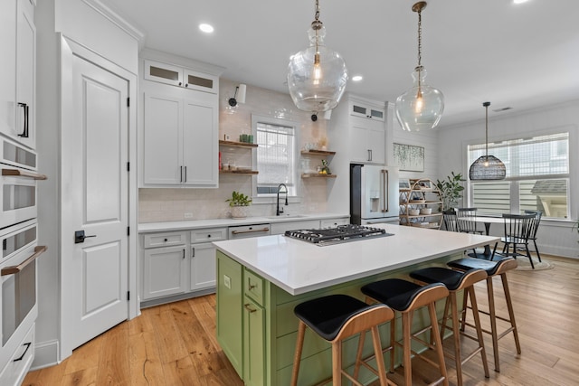 1530 Willtown St, Daniel Island, SC 29492 - kitchen featuring white appliances, a breakfast bar area, decorative backsplash, a kitchen island, and white cabinetry
