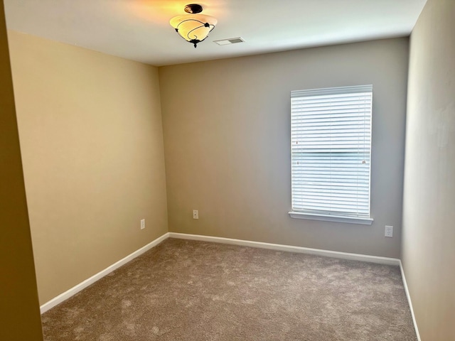 spare room featuring carpet flooring and baseboards