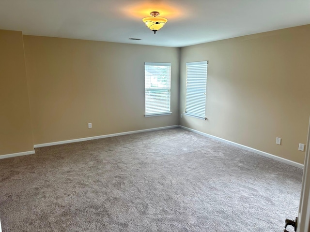 carpeted spare room with baseboards