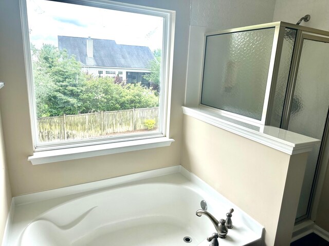 full bathroom featuring a bath and a shower stall
