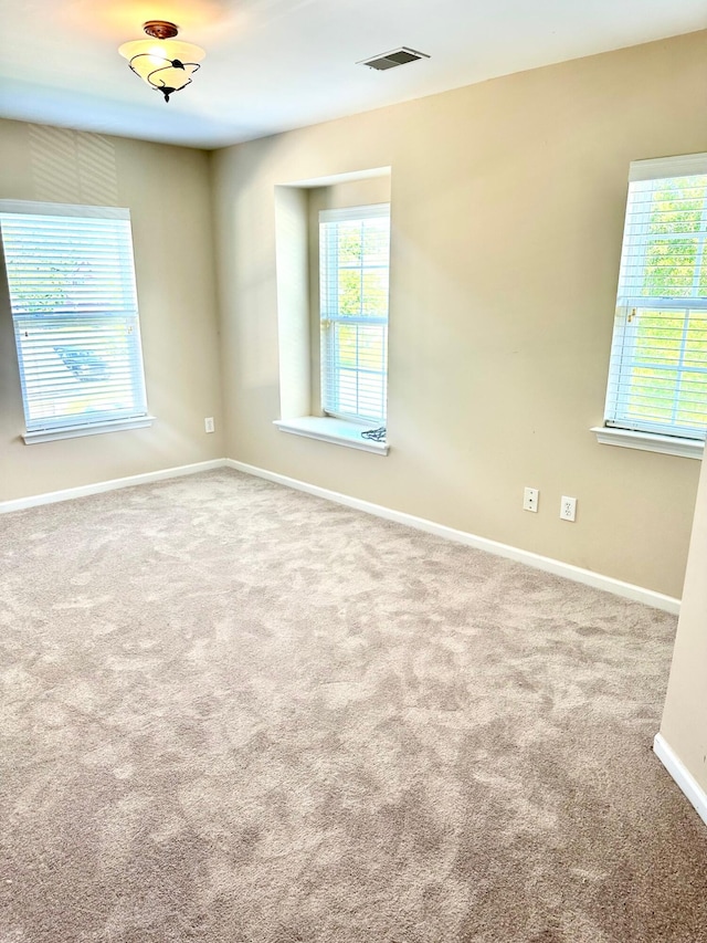 carpeted empty room with baseboards