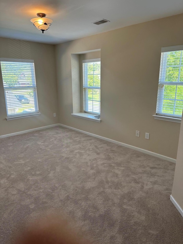 carpeted empty room featuring baseboards