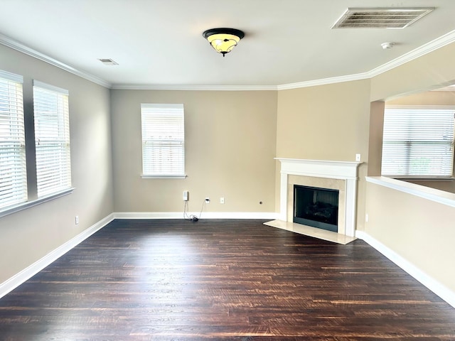 unfurnished living room with plenty of natural light, wood finished floors, a fireplace, ornamental molding, and baseboards