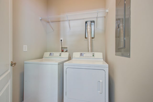 laundry room featuring electric panel and washing machine and clothes dryer