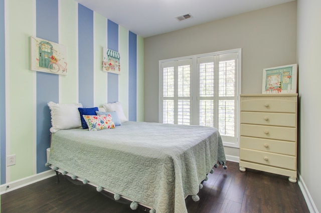 bedroom with multiple windows and dark hardwood / wood-style flooring