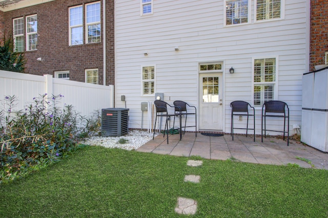 back of property with a patio area, a yard, and cooling unit