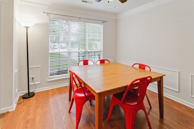 dining area with plenty of natural light, light wood-style floors, ornamental molding, baseboards, and a ceiling fan