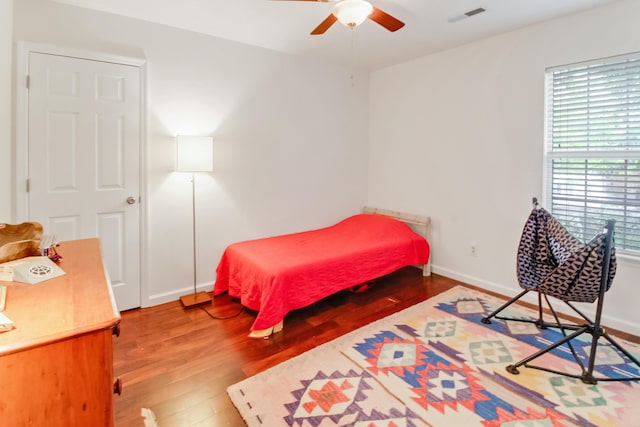 bedroom with wood finished floors, baseboards, and a ceiling fan