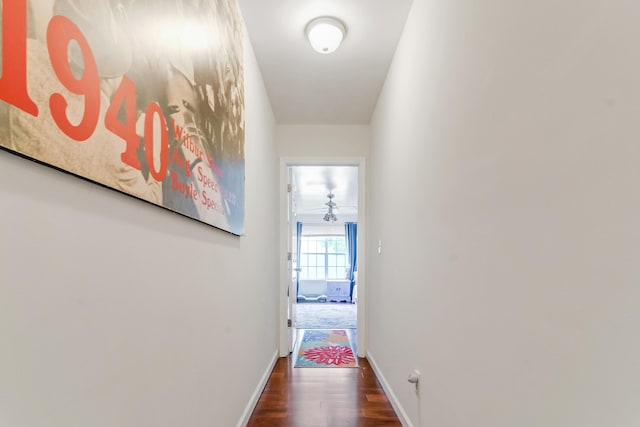 hallway featuring wood finished floors and baseboards