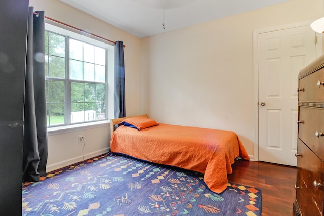 bedroom featuring wood finished floors and baseboards