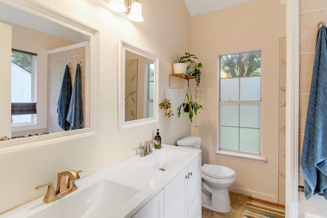 bathroom featuring toilet, double vanity, and tile patterned flooring