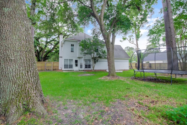 back of property featuring a trampoline and a chimney