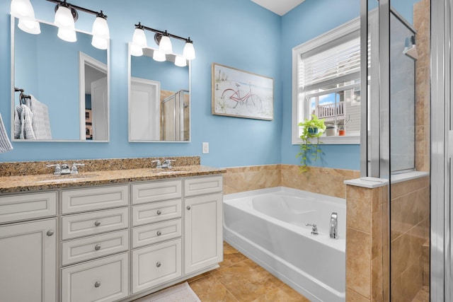 full bath with double vanity, a sink, a shower stall, tile patterned flooring, and a bath