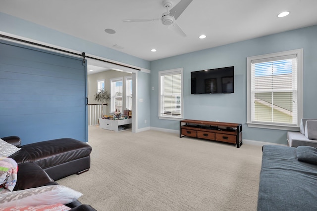 living room featuring a barn door, recessed lighting, carpet flooring, and a healthy amount of sunlight